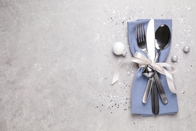 Photo of Cutlery set on grey table, top view with space for text. Christmas celebration