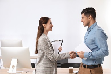 Employee shaking hands with intern in office