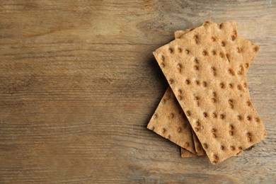 Fresh rye crispbreads on wooden table, top view. Space for text