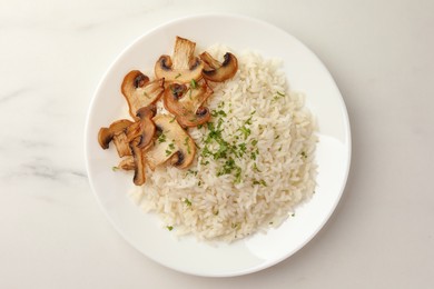 Photo of Delicious rice with parsley and mushrooms on white marble table, top view