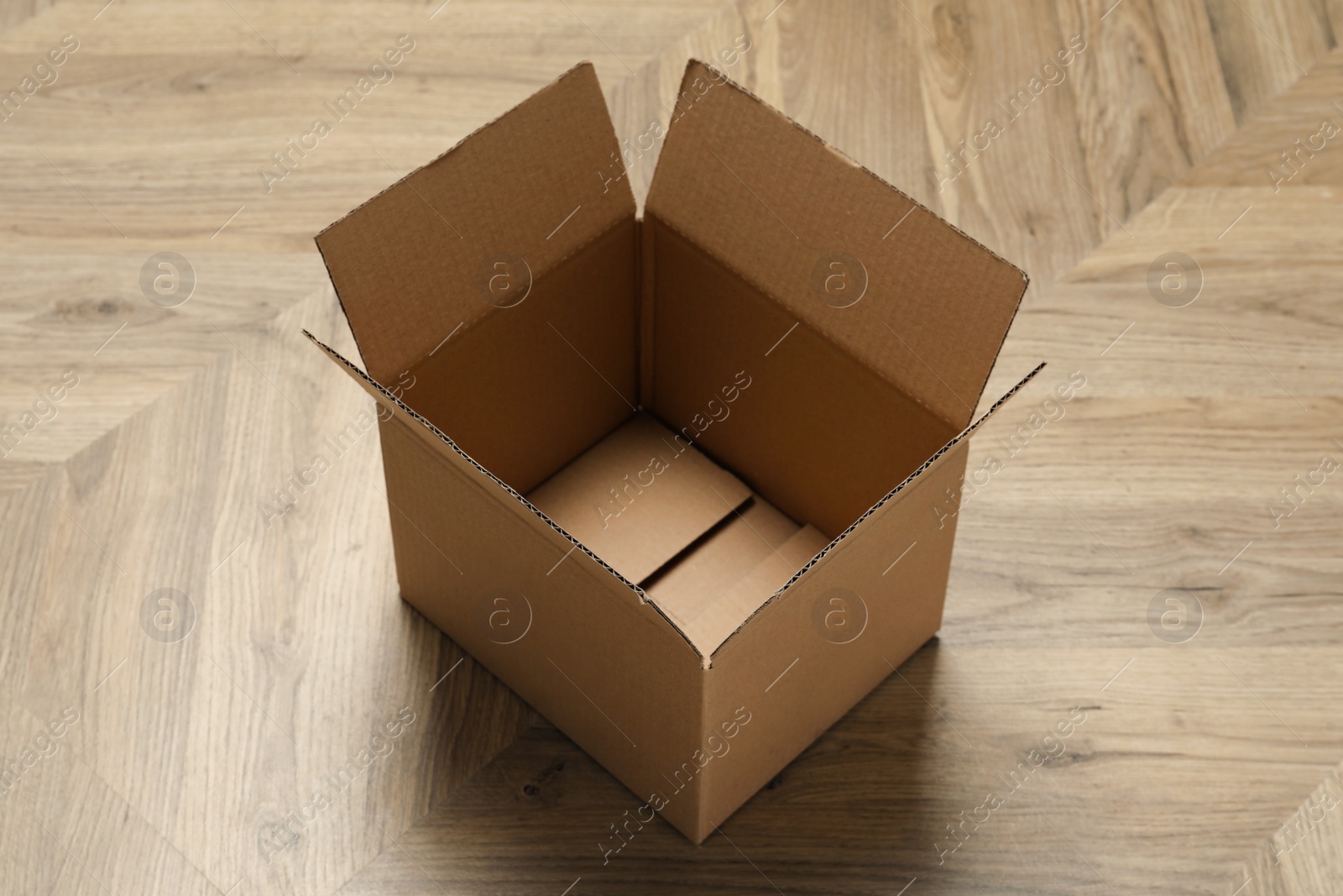 Photo of One empty open cardboard box on floor