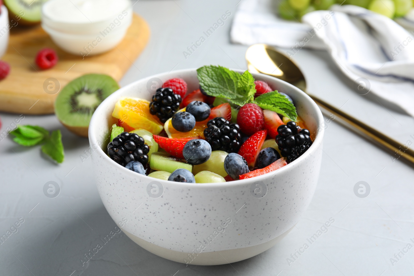 Photo of Fresh tasty fruit salad on grey table