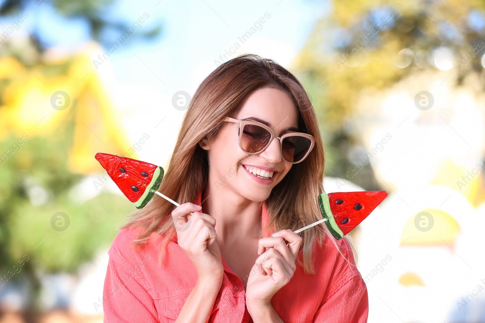 Photo of Young happy woman with sweet candies outdoors