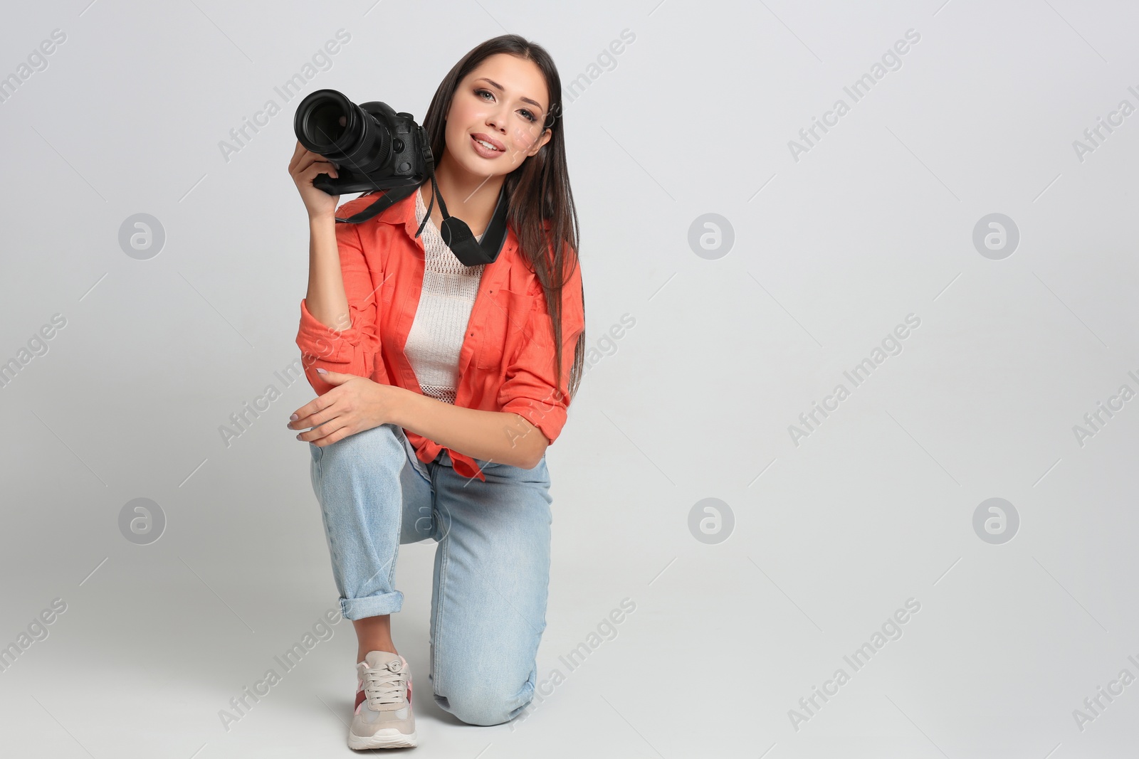 Photo of Professional photographer working on white background in studio