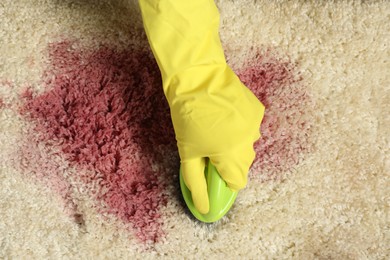 Photo of Woman removing stain from beige carpet, top view