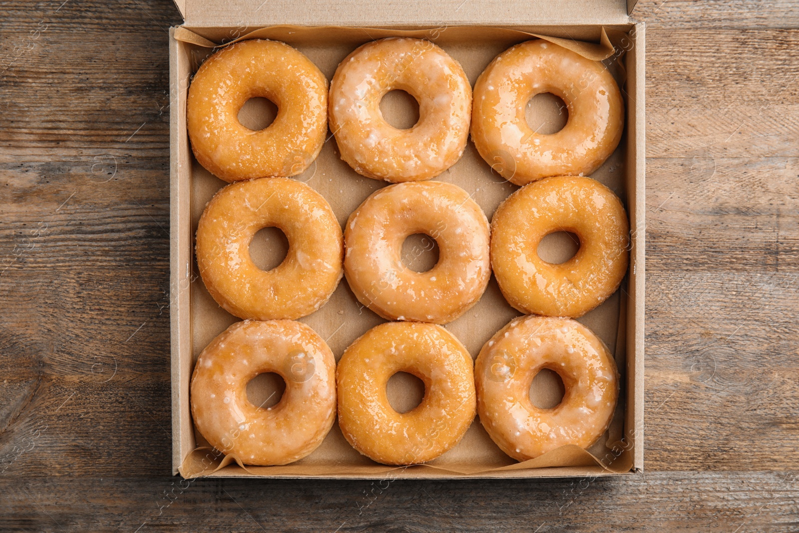 Photo of Delicious donuts on wooden table, top view