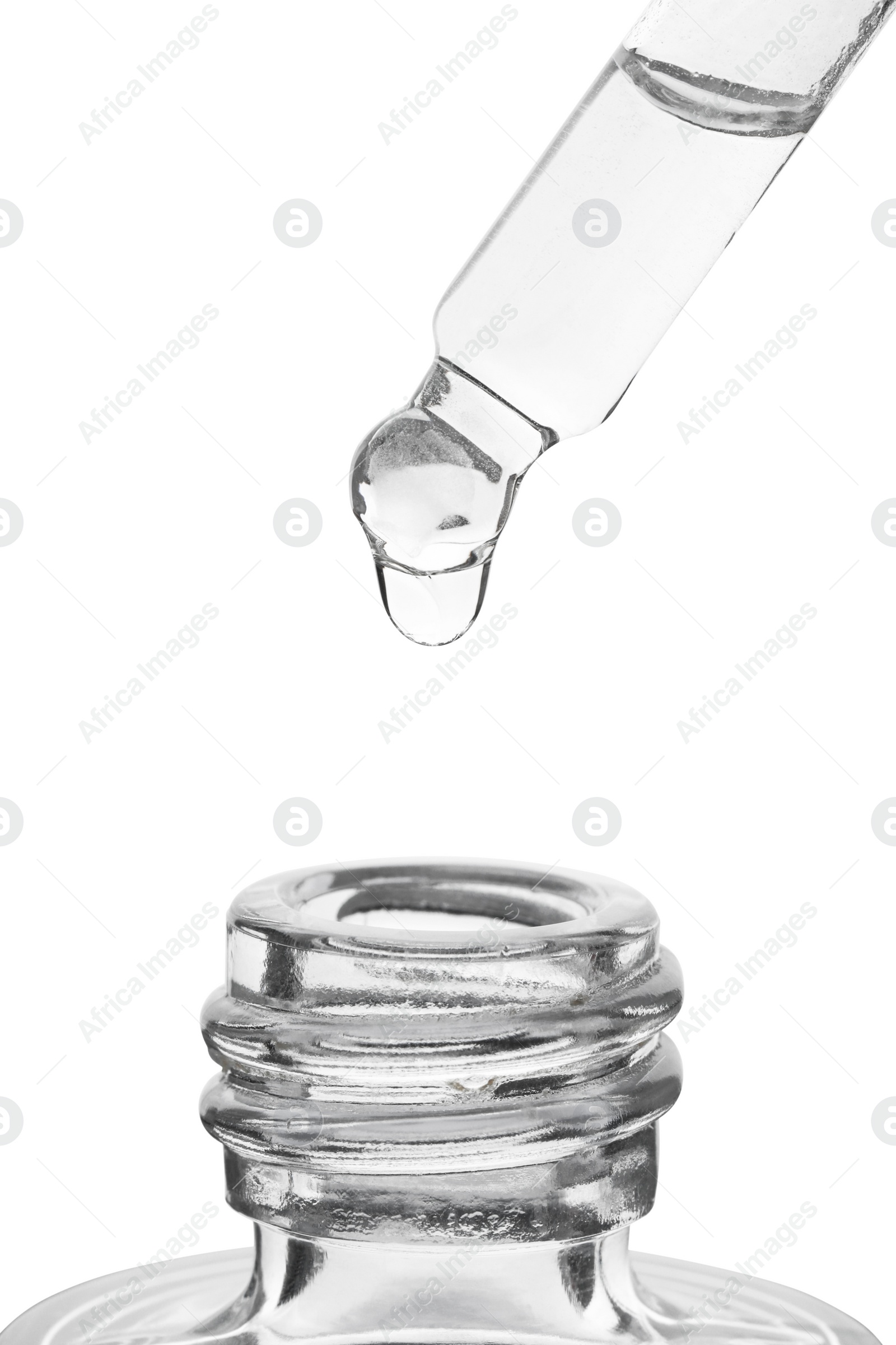 Photo of Dripping clear facial serum from pipette into glass bottle on white background, closeup