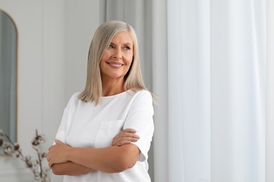 Portrait of beautiful middle aged woman at home, space for text