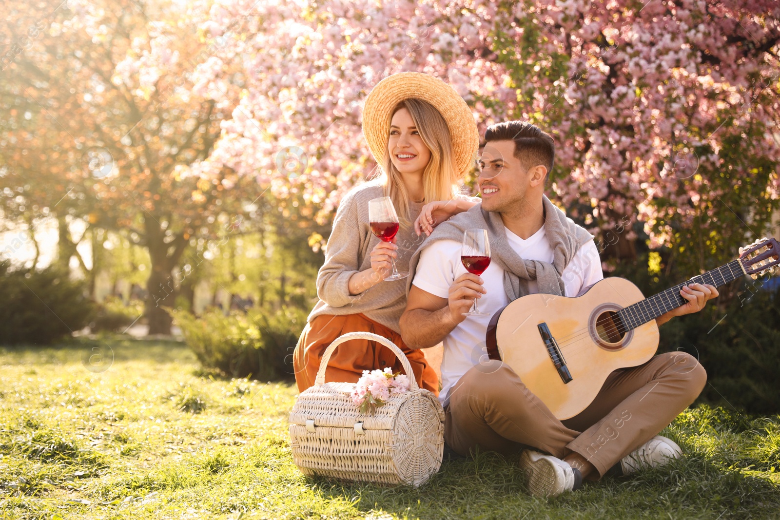 Photo of Lovely couple having picnic in park on sunny spring day