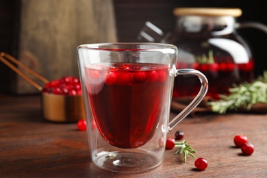 Photo of Tasty hot cranberry tea on wooden table