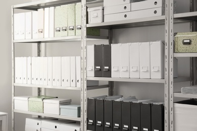 Folders with documents on shelves in archive