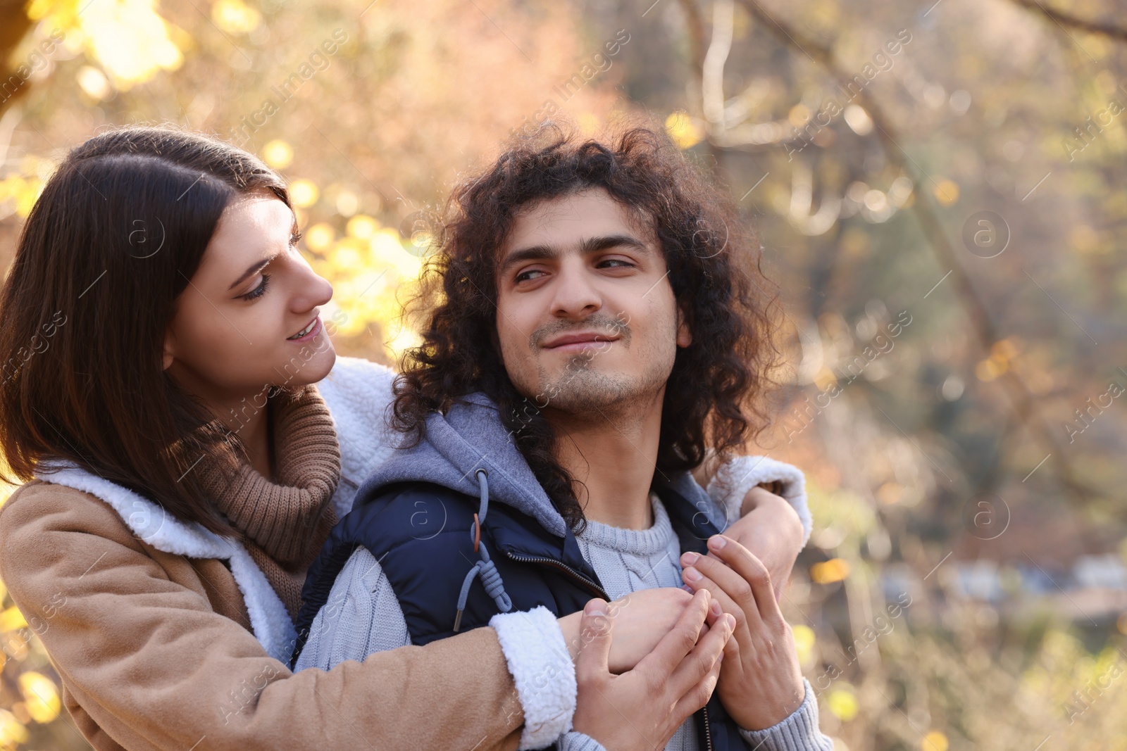 Photo of Happy young couple spending time together in autumn park, space for text. Dating agency