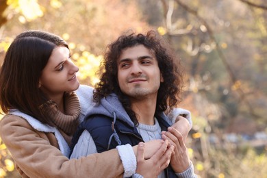 Photo of Happy young couple spending time together in autumn park, space for text. Dating agency