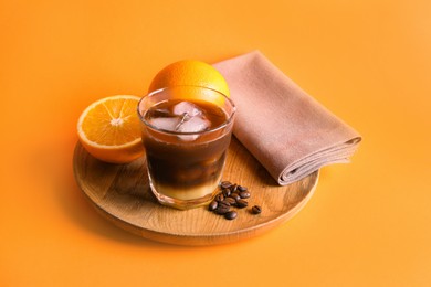 Tasty refreshing drink with coffee and orange juice on bright color background