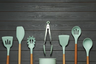Set of different kitchen utensils on grey wooden table, flat lay with space for text