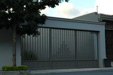 Photo of Beautiful closed metal gate and fence outdoors