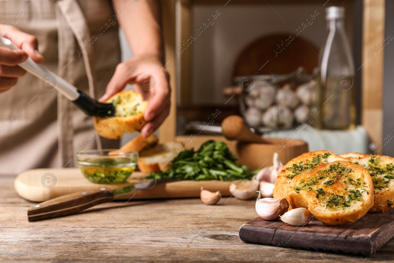 Photo of Slices of toasted bread with garlic and blurred woman on background