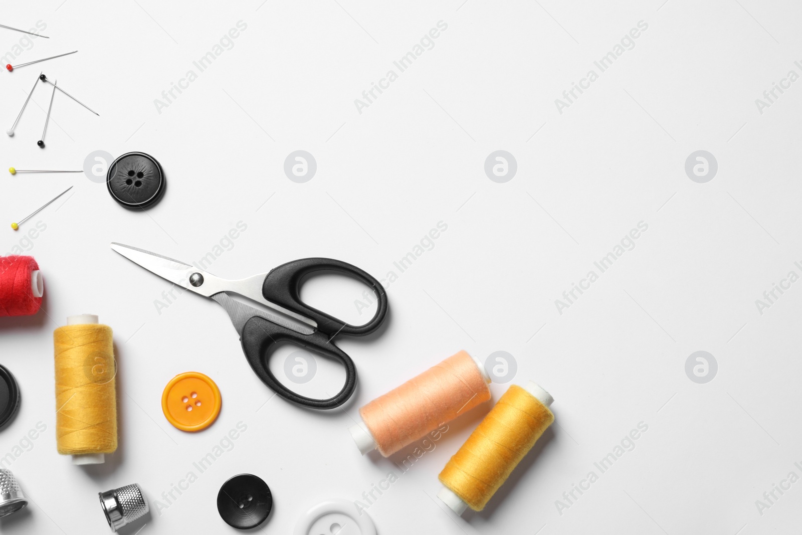 Photo of Composition with scissors and other sewing accessories on white background, top view