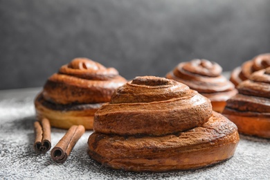 Cinnamon rolls and sugar powder on table