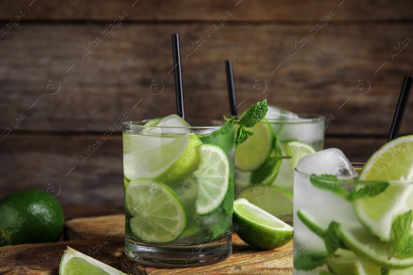 Photo of Delicious mojito and ingredients on wooden table