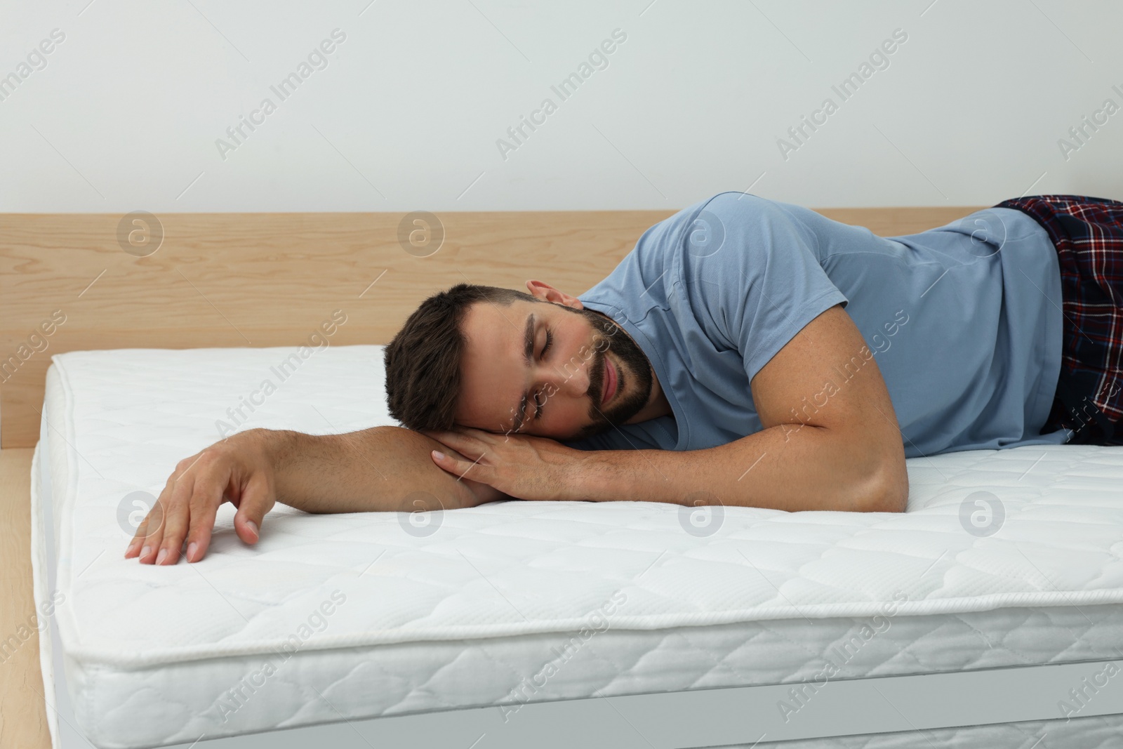 Photo of Man sleeping on bed with comfortable mattress at home