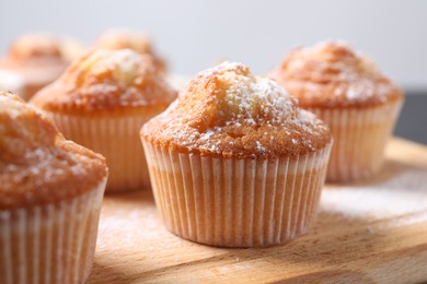 Delicious sweet muffins on wooden board, closeup