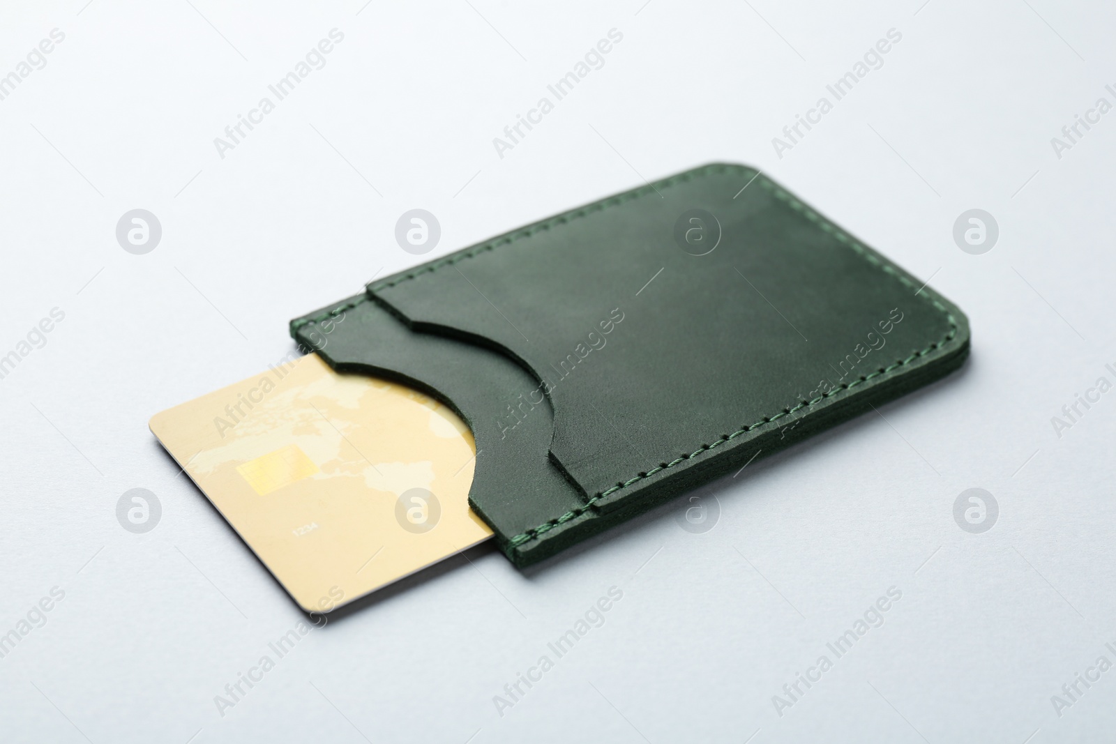Photo of Woman holding leather card holder with credit card on light grey background