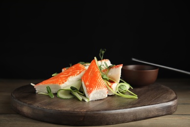 Photo of Fresh crab sticks with cucumber and soy sauce served on wooden table