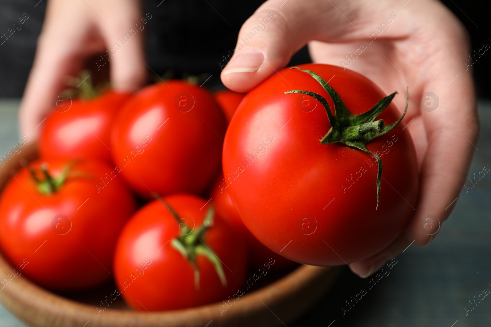 Photo of Woman with ripe tomatoes at table, closeup