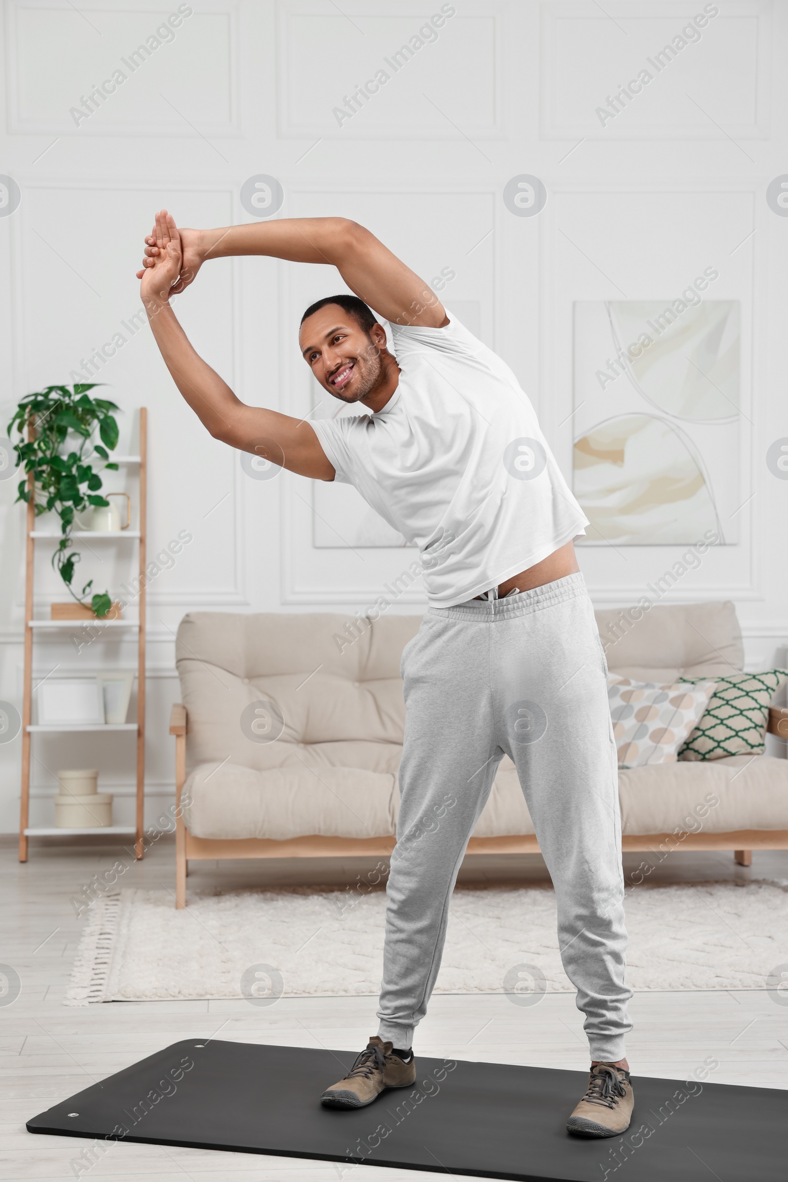 Photo of Man doing morning exercise on fitness mat at home