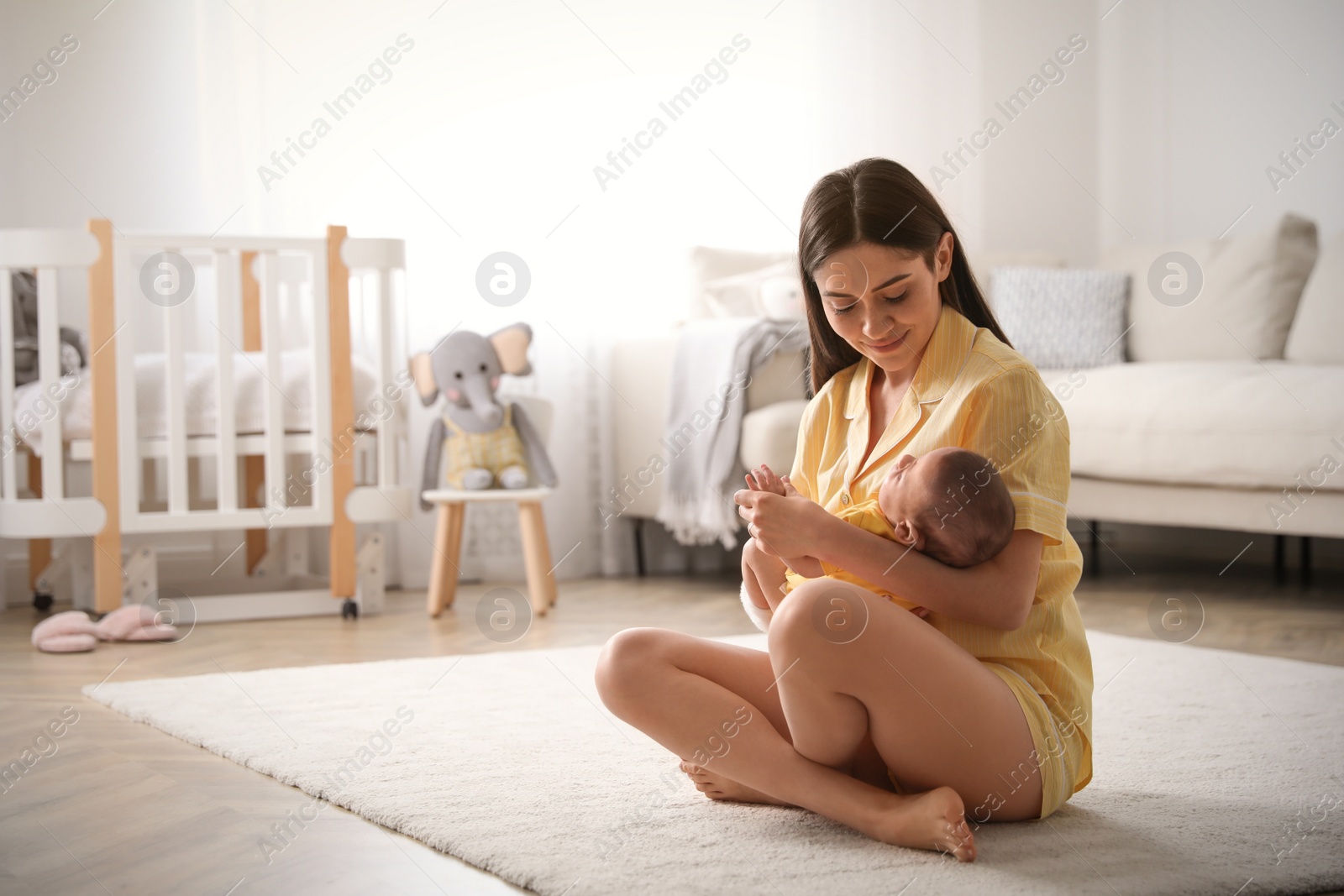 Photo of Young woman with her cute baby at home, space for text