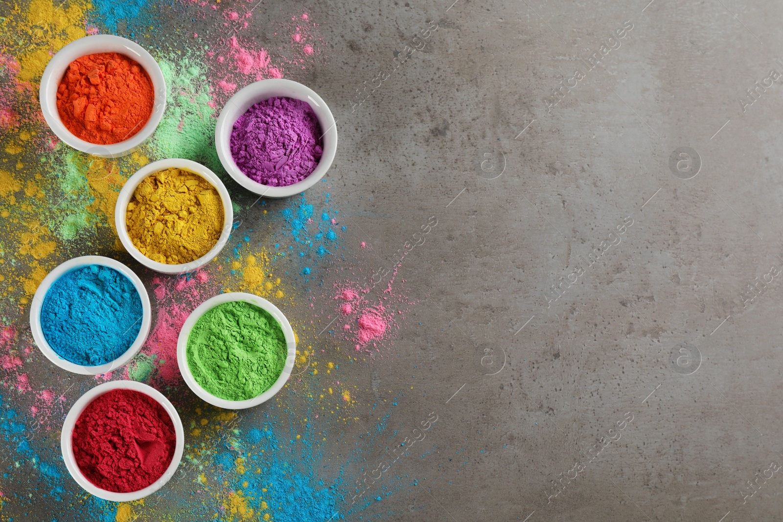 Photo of Colorful powder dyes on grey background, flat lay with space for text. Holi festival