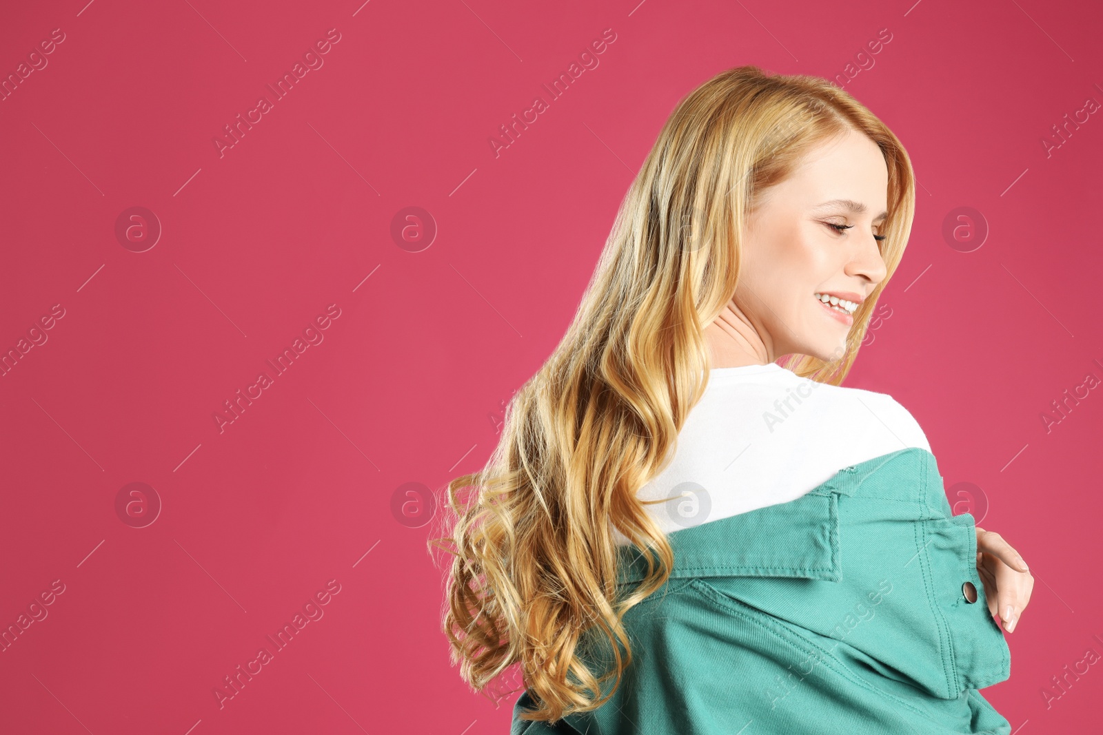 Photo of Portrait of beautiful young woman with dyed long hair on pink background. Space for text