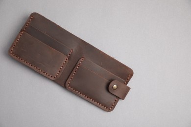 Photo of Stylish brown leather wallet on light grey background, top view. Space for text