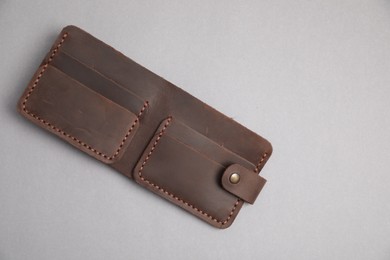 Stylish brown leather wallet on light grey background, top view. Space for text