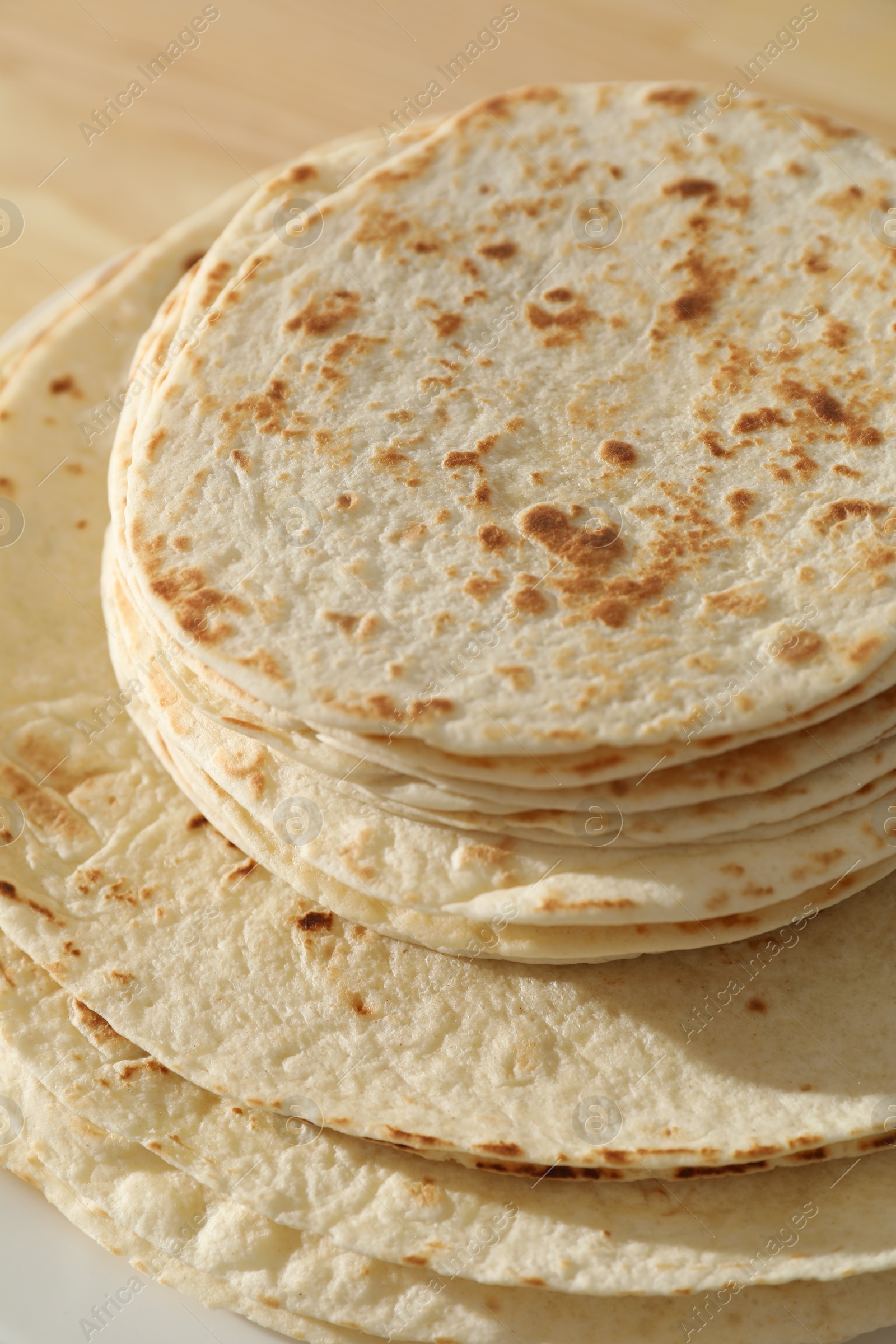 Photo of Many tasty homemade tortillas on table, closeup