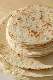 Photo of Many tasty homemade tortillas on table, closeup