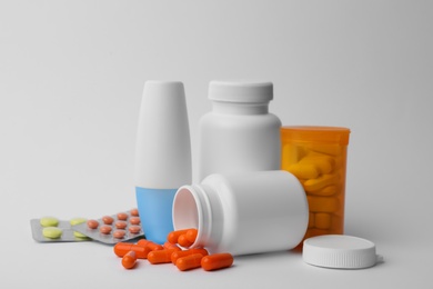 Containers and different pills on white background