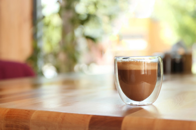 Aromatic coffee on wooden table in cafe. Space for text