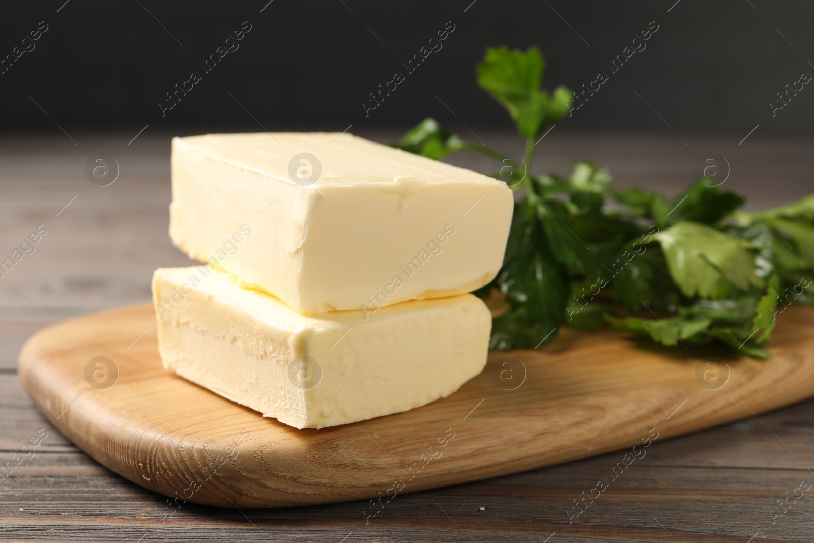 Photo of Tasty butter and parsley on wooden table, closeup