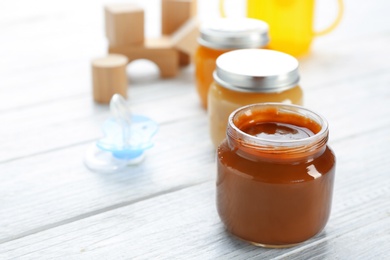 Jars with tasty baby food on table