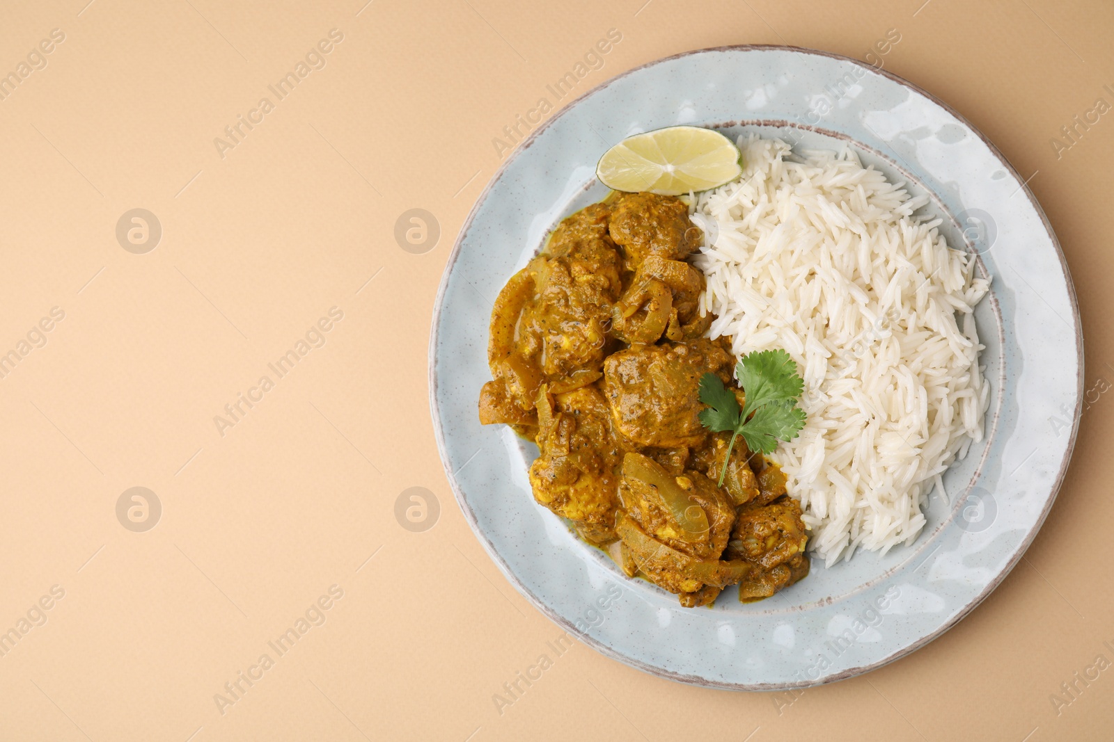 Photo of Delicious chicken curry with rice on beige background, top view. Space for text