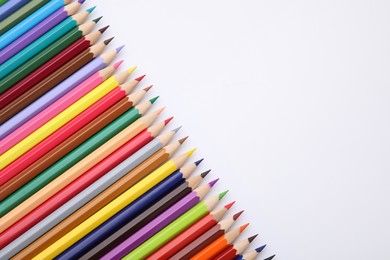 Colorful wooden pencils on white background, flat lay. Space for text