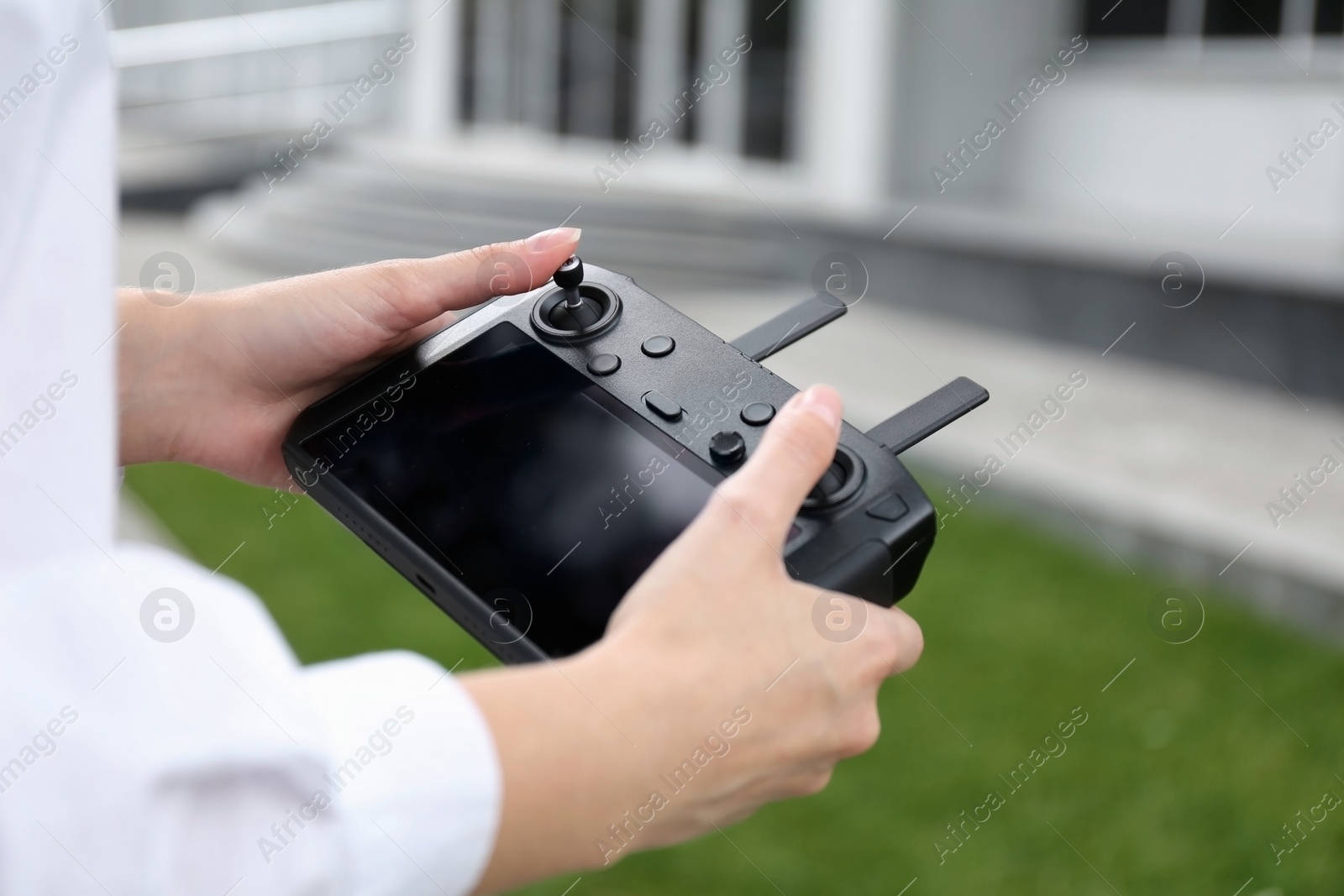 Photo of Woman with modern drone controller outdoors, closeup