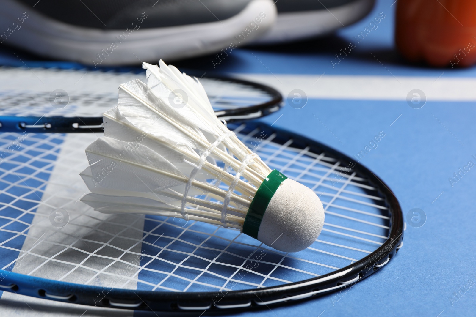 Photo of Feather badminton shuttlecock and rackets on court, closeup