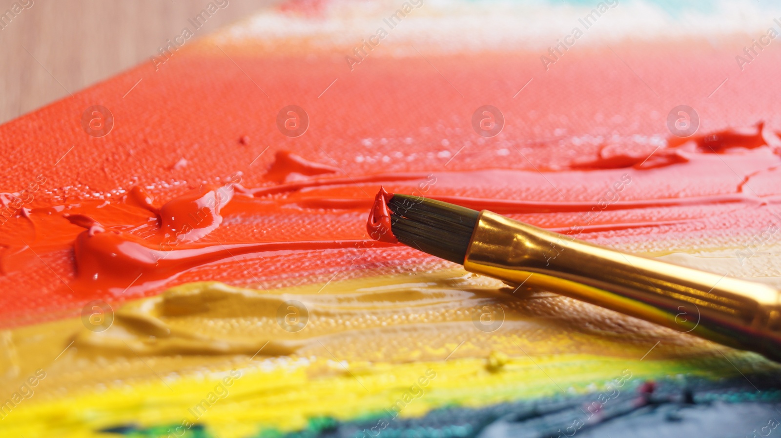 Photo of Brush on artist's palette with colorful mixed paints, closeup