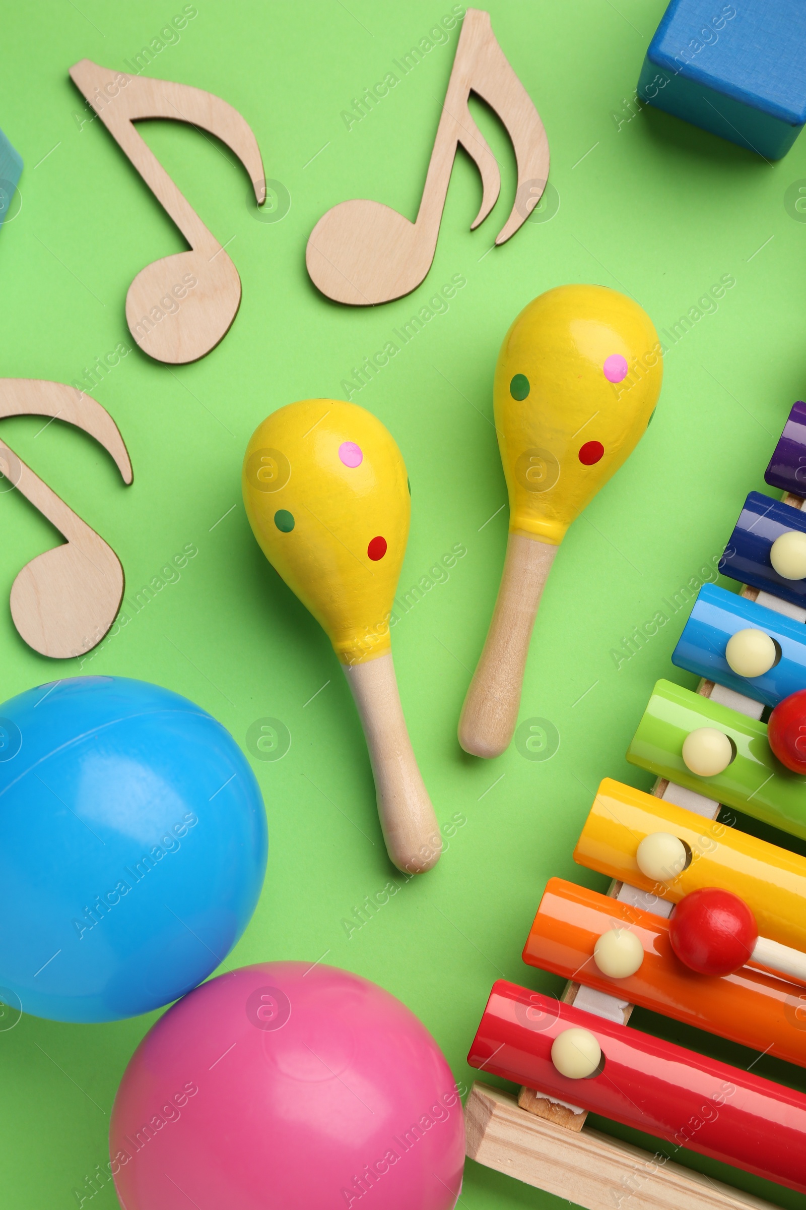 Photo of Tools for creating baby songs. Flat lay composition with maracas on green background