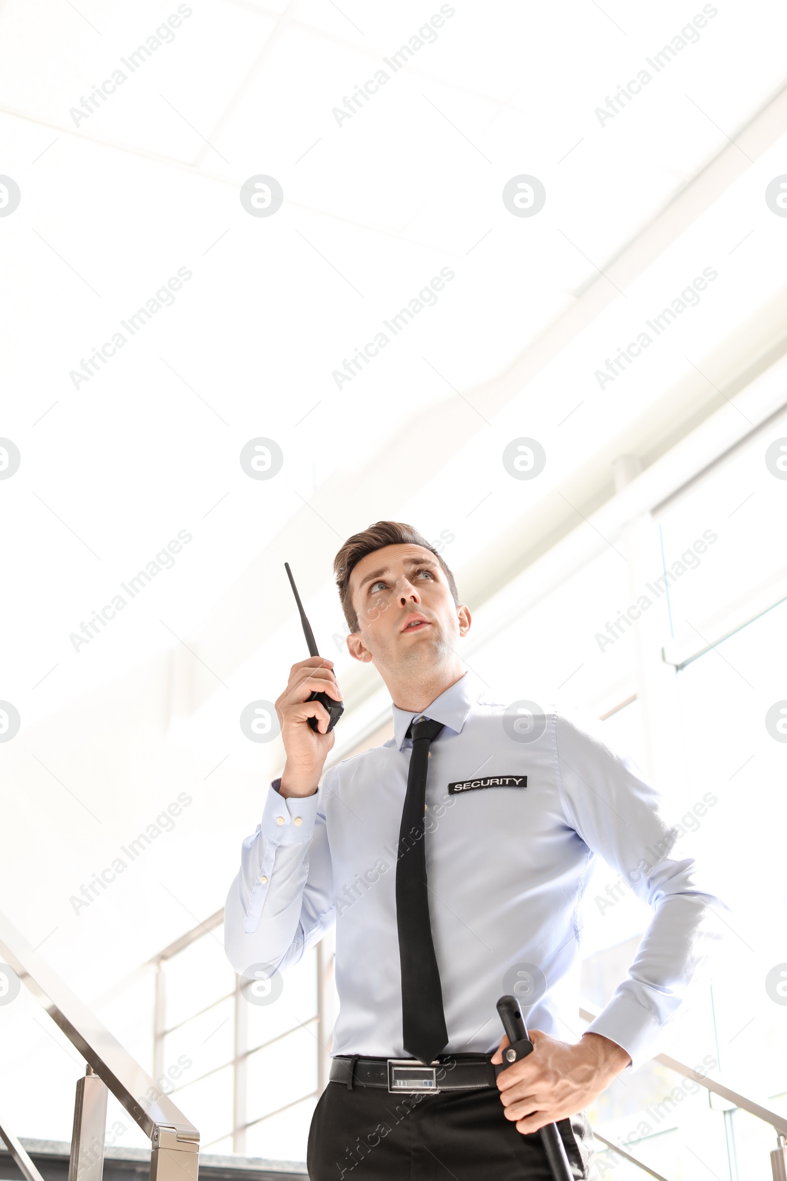 Photo of Male security guard with portable radio transmitter indoors