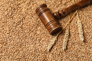 Wooden gavel and wheat ears on grains, closeup. Agricultural deal