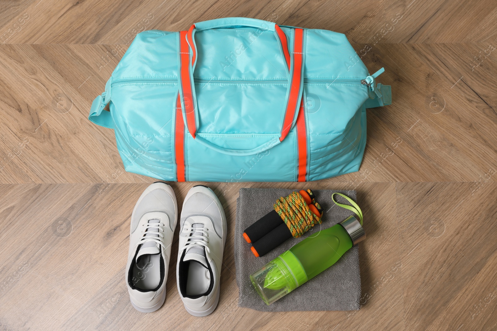 Photo of Blue gym bag and sports accessories on wooden floor, flat lay